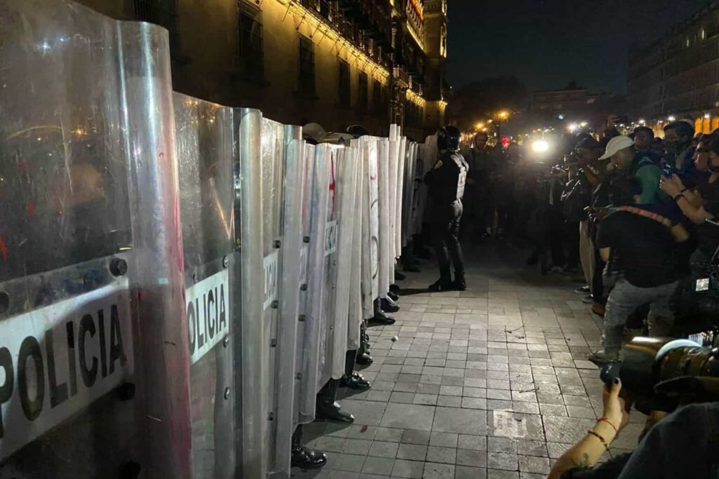 Enfrentamiento entre policías y manifestantes durante la vigilia en el Zócalo
